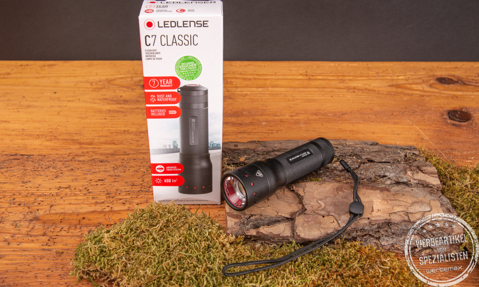 Fachhandelsverpackung der LEDLenser Classic C7 aus Karton mit Sichtfenster. Daneben liegt die Taschenlampe selbst. Klein, kompakt aber unglaublich Leistungsstark.