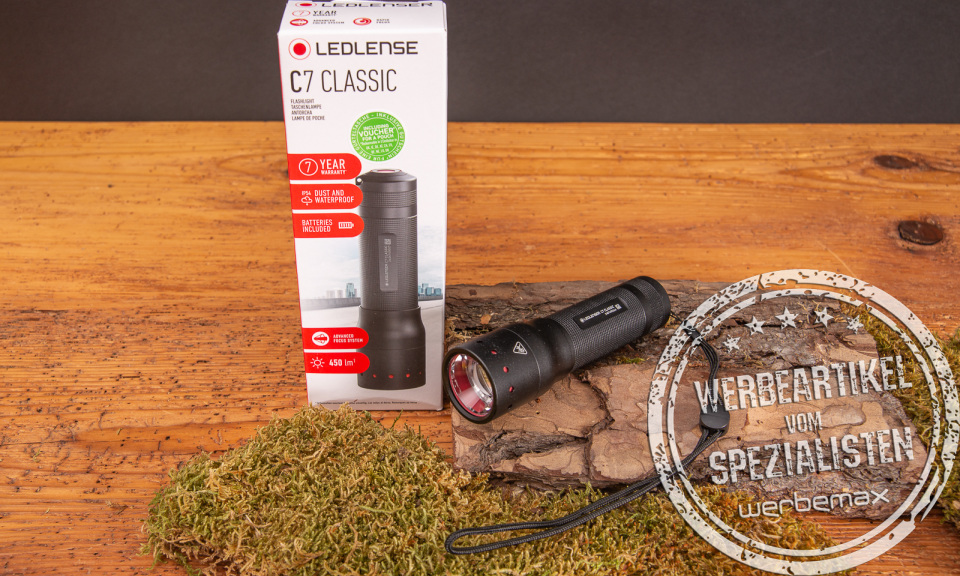 Fachhandelsverpackung der LEDLenser Classic C7 aus Karton mit Sichtfenster. Daneben liegt die Taschenlampe selbst. Klein, kompakt aber unglaublich Leistungsstark.