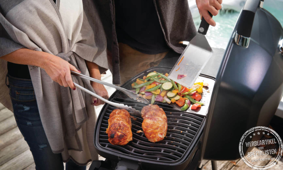 Napoleon Grill belegt mit Grillgut und Grillzubeh&ouml;r.