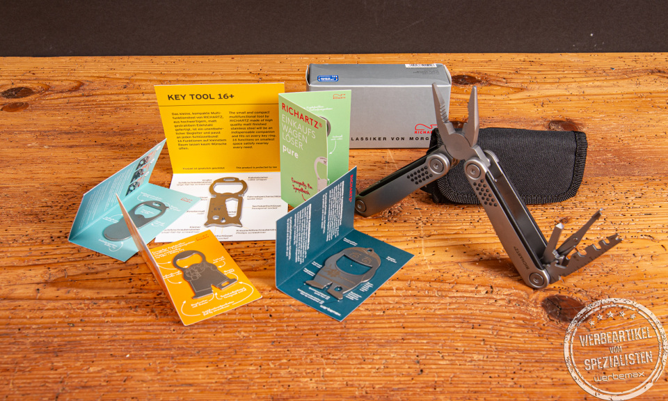Richartz Werbeartikel: Multitools, Flaschenöffne und bedruckten Infokarten auf Holzfläche – ideal als hochwertige Werbegeschenke mit Logo.