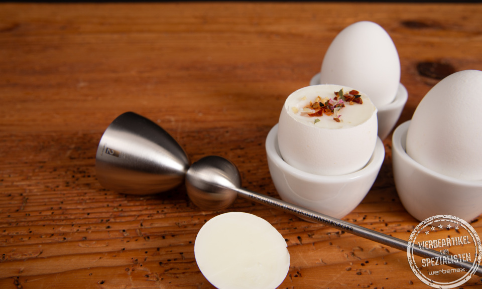 Detailaufnahme des Clack Eieröffners nach der Anwendung – geöffnetes Frühstücksei mit Kräutern serviert.