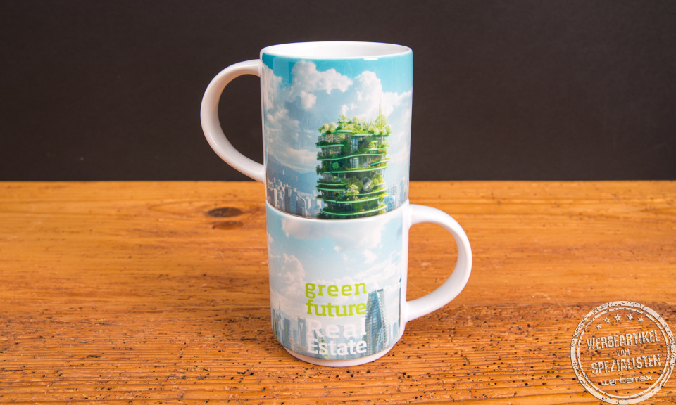 Zwei &uuml;bereinander gestapelte Werbetassen mit gr&uuml;nem City-Motiv und Skyline &ndash; bedruckte Mahlwerck Tassen als nachhaltige Werbeartikel f&uuml;r Unternehmen.