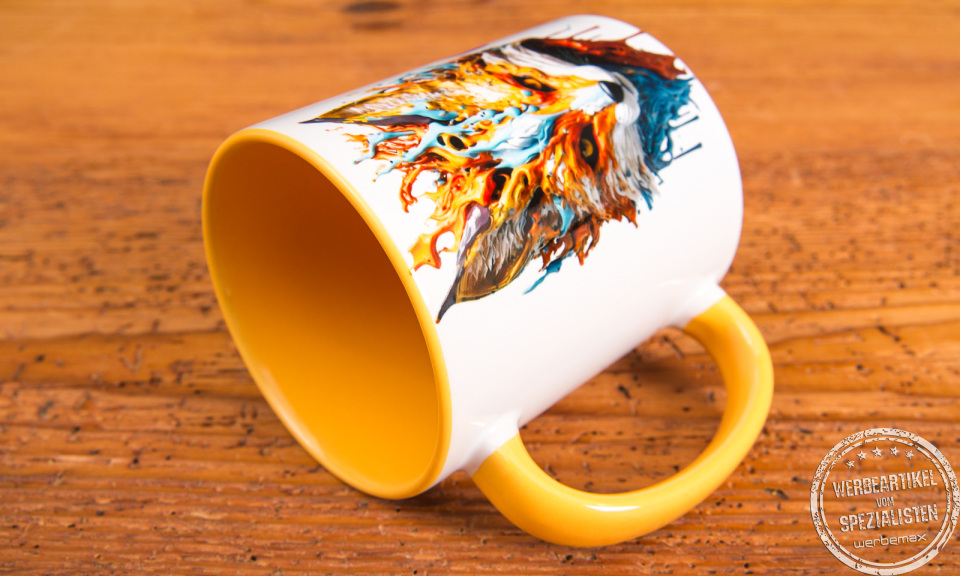 Keramiktasse mit gelber Innenglasur und farbstarkem Fuchs-Motiv – kreativ bedruckte Werbeartikel Tasse auf rustikalem Hintergrund.