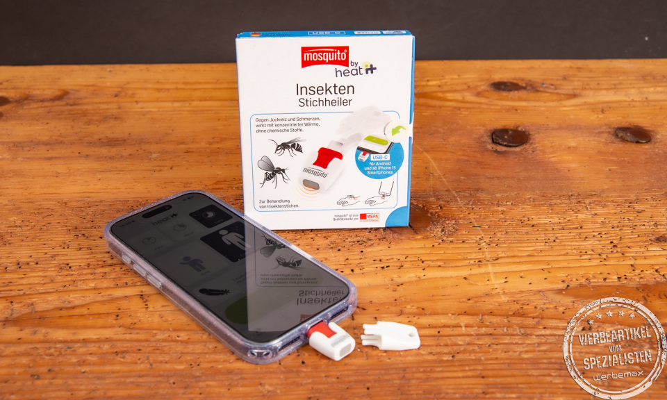 heat it Insektenstichheiler mit Smartphone und Verpackung – chemiefreies Sommer-Gadget als nachhaltiger Werbeartikel mit Logo.