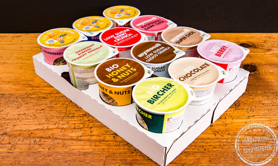 Bio-Müsli Becher von mymuesli als Streuartikel im Karton-Tray präsentiert.