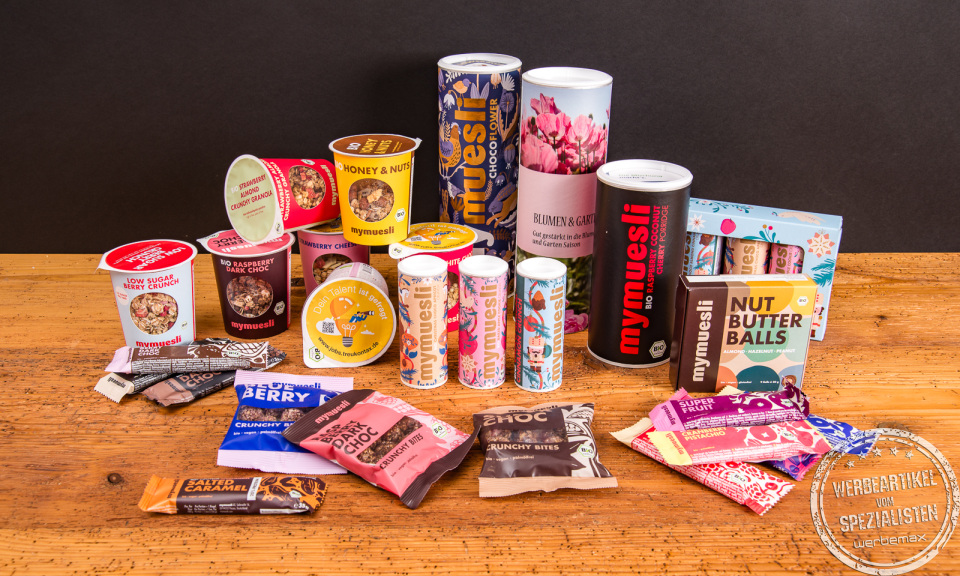 Vielf&auml;ltiges mymuesli Sortiment mit M&uuml;slibecher to go, Dosen und Riegeln &ndash; nachhaltige Werbegeschenke im &Uuml;berblick.