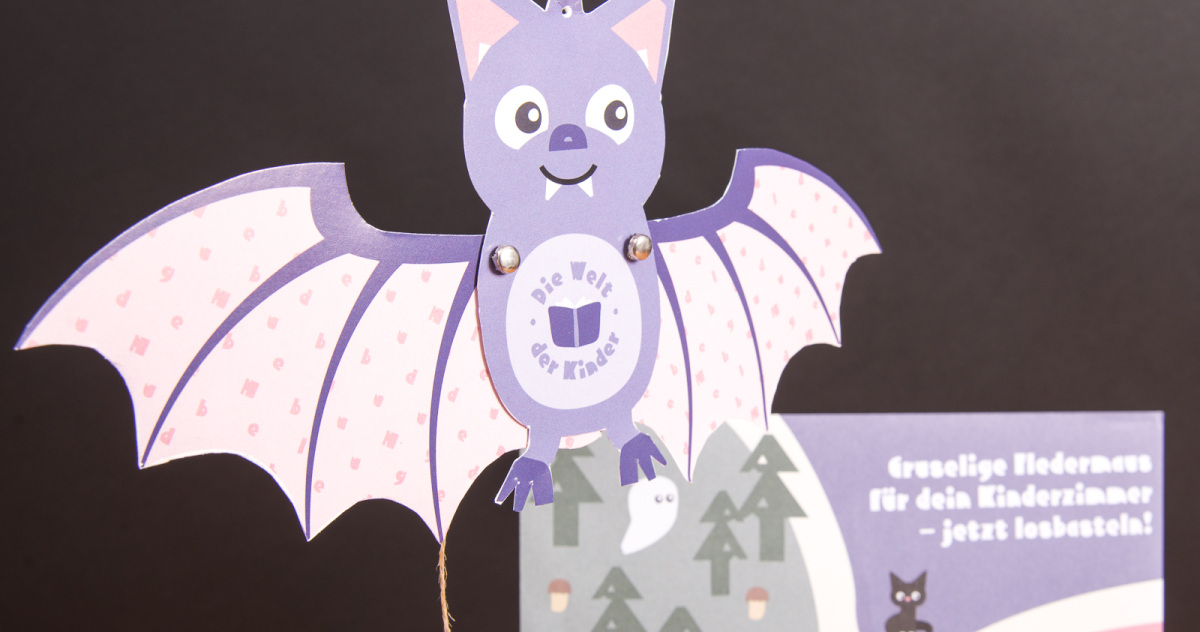 Gebastelte lila Fledermaus aus dem Halloween-Bastelset für Kinder, umgesetzt als kreativer Werbeartikel für Hugendubel.