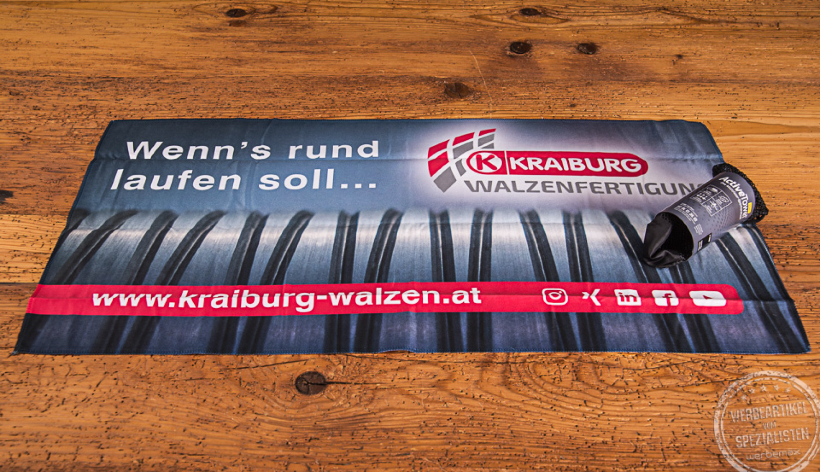 Ausgebreitetes ActiveTowel Handtuch mit Fotodruck Kraiburg Holding als Mitarbeitergeschenk. 