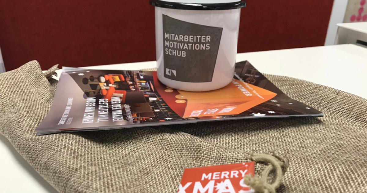 Weihnachtsgeschenk Emaille Becher mit Logo und Spruch Mitarbeiter Motivations Schub für König + Neurath. 