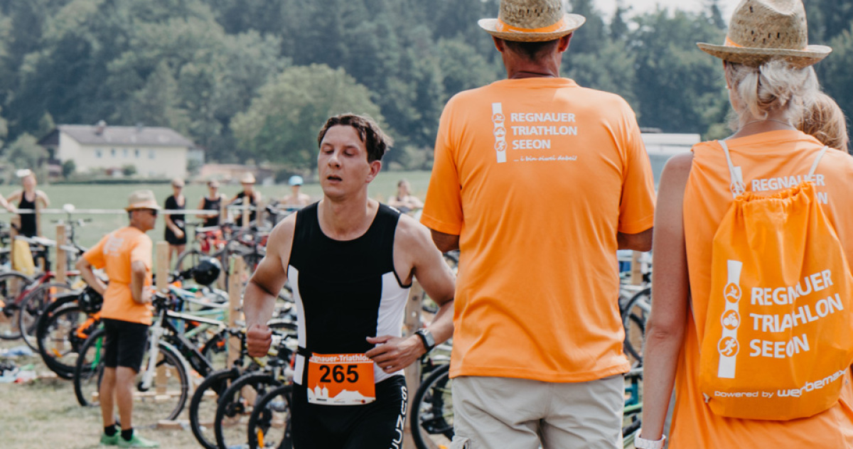 Regenauer Triathlon Seeon orangfarbene Matrucksäcke mit weißem Aufdruck und passende Strohhüte