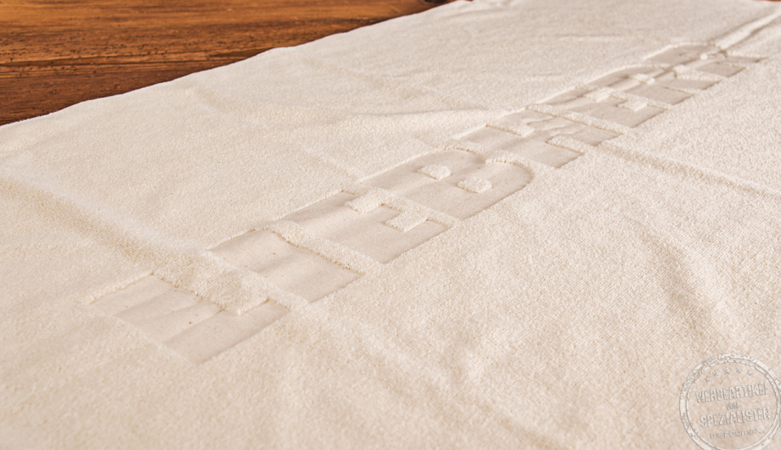  Liegendes UNDYED Handtuch mit Logo Liebherr als Werbegeschenk.