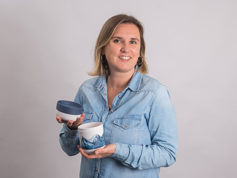Carolin Specht, werbemax Marketing Managerin mit einer Tasse als Werbegeschenk in der Hand.