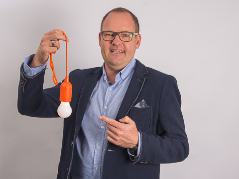 Christian H&ouml;fling, werbemax Gesch&auml;ftsf&uuml;hrer, mit einer Lampe als Werbeartikel in der Hand. 