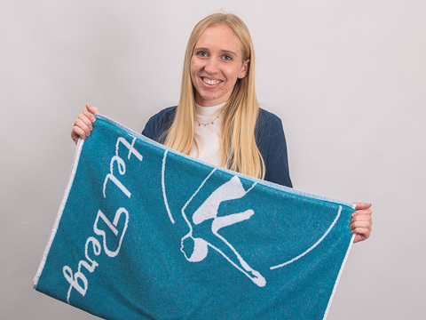 Veronika Gartner, werbemax Kundenberaterin mit einem Handtuch als Werbegeschenk. 
