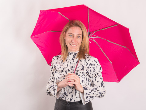 Kundenberaterin Christine Knoll mit Regenschirm von Fare als Werbeartikel in der Hand.