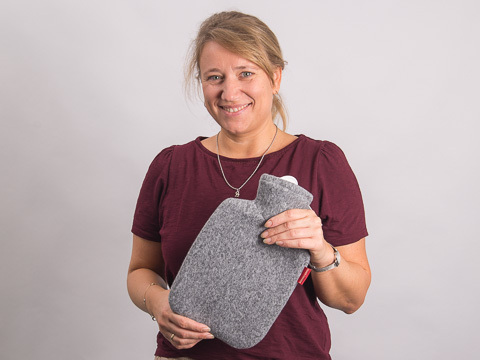 Kundenberaterin Irina Belger mit Wärmflasche in der Hand.