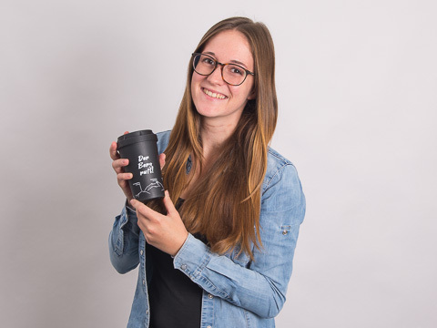 Kundenberaterin Melanie Brenner mit Coffee To Go Becher in der Hand.