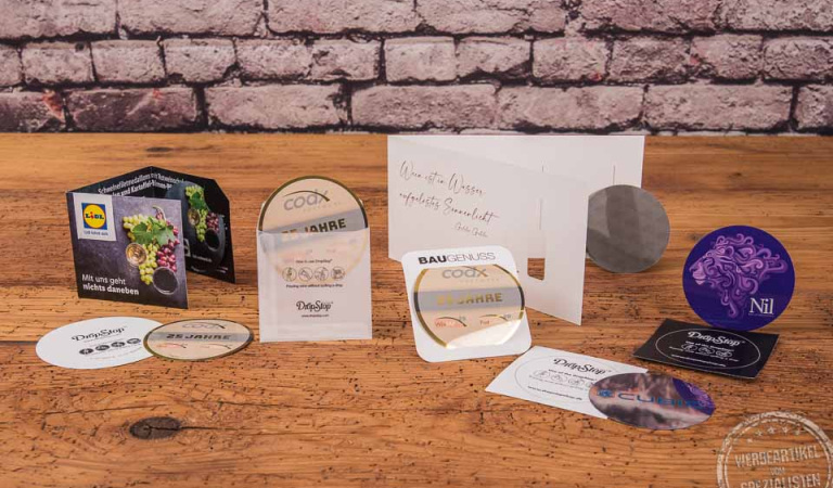 Drop Stop Weinausgießer diverse Umsetzungsbeispiel mit Fotodruck und Verpackungsgestaltung auf Holztisch. 