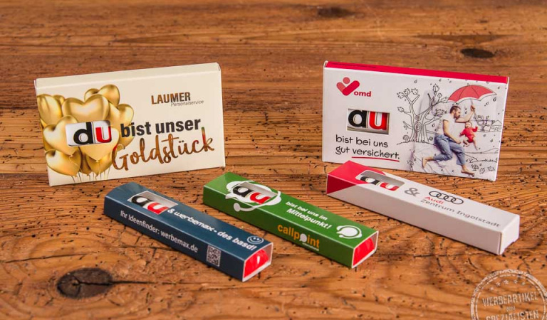 Verschiedene Duplo Schokoriegel in individuell bedruckten 1er- und 3er-Werbeschubern mit emotionalen Botschaften wie „Du bist unser Goldstück“ oder „Du bist bei uns gut versichert“ – kreative Werbeartikel für HR, Events und Marketingaktionen.