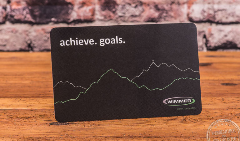 Schneidebrett Bergmotiv als bedruckter Merchandise Artikel stehend vor Steinmauer