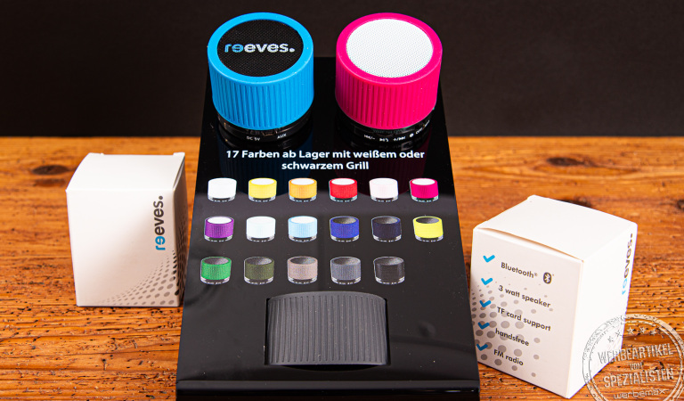 Zwei Bluetooth Speaker in schwarz und weiß auf einem schwarzen Acryl-Display.