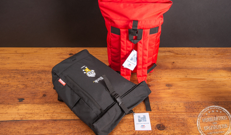 Zwei Rolltop-Rucksäcke mit Logo als Werbeartikel.