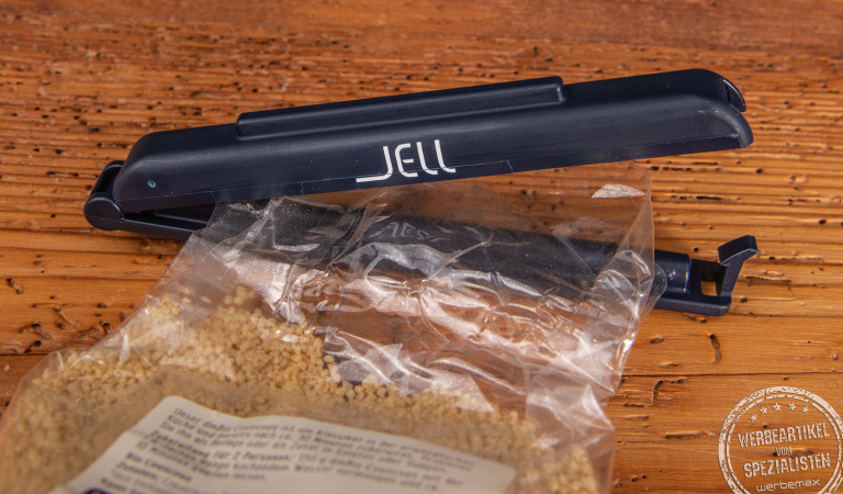 T&uuml;tenclips als langlebige und g&uuml;nstige Werbeartikel. Hier ein JELL T&uuml;tenclip DACLIPA in schwarz mit wei&szlig;em Logo