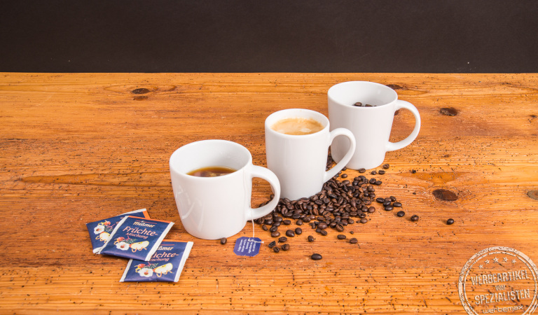 Drei SND Porzellanbecher nebeneinander mit Tee, Kaffee und Bohnen – vielseitige Werbebecher aus Porzellan.