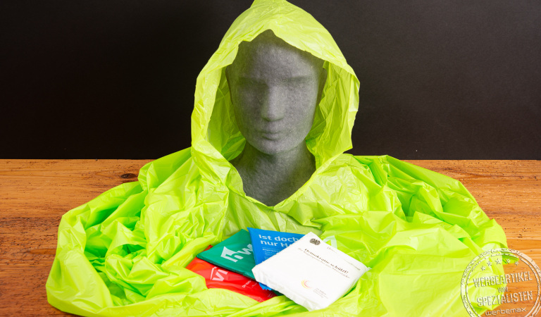 Grüner Regenponcho aus biologisch abbaubarer Maisstärke mit Verpackungen in verschiedenen Farben – nachhaltiger Poncho mit Logo als Werbeartikel für Festivals, Events und Tourismus von werbemax.
