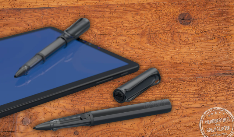 LAMY AL-star EMR Tablet-Stift neben einem blauen Tablet-Display auf Holztisch – hochwertiger Stylus Pen für Touchscreens und EMR-kompatible Geräte, ideal als digitales Mitarbeitergeschenk oder Premium-Werbeartikel.