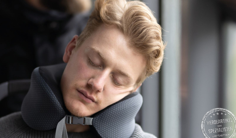 Anwendung des TROIKA Business Travel Pillow als Nackenkissen im Flugzeug zur Nackenentlastung
