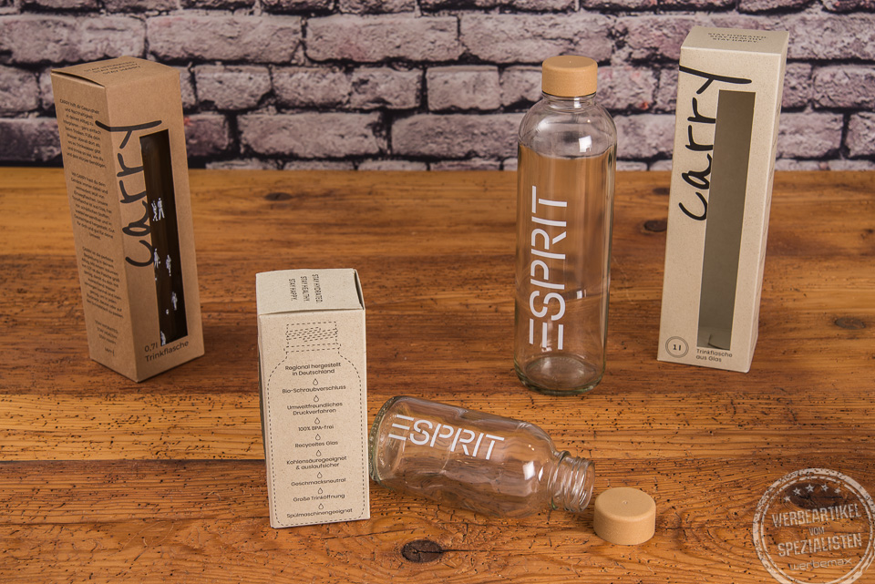 Glasflasche mit Logo als Mitarbeiter- und Kundengeschenk in verschiedenen Gr&ouml;&szlig;en auf Holztisch.